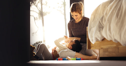 Smiling woman playing with little boy