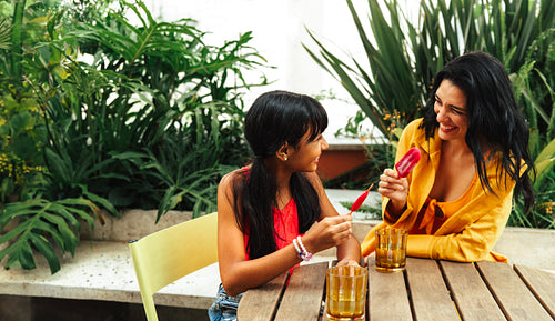 Mother and daughter sharing a joyful moment in a lush garden setting