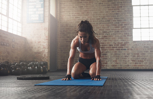 Young woman doing a forward bend exercise on fitness mat
