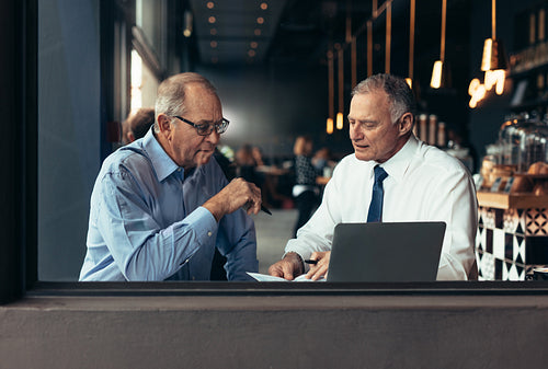 Senior businessmen at cafe working on new project