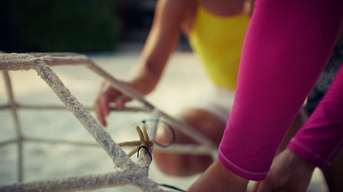 Family and children engage in coral reef restoration efforts on a tropical beach
