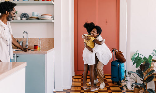 Mother arriving home to her daughter's warm welcome after travelling
