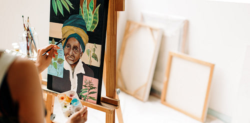 Anonymous female painter working on a portrait