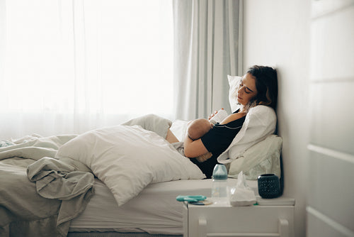 Mother nursing baby in bedroom