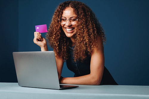 The woman completes online payment with a credit card at home