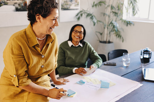 Cheerful mature businesswoman leading a collaborative meeting in a bright office