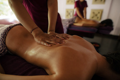 Masseuse massaging woman at health spa