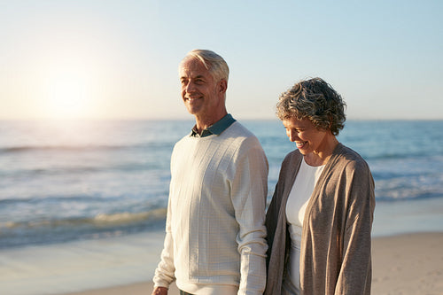 Happy mature couple walking along the beach