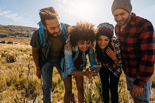 Group of young people hiking in nature and taking pictures