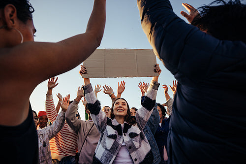 Group of individuals celebrating freedom with a female holding a blank sign