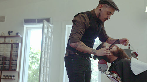 Client getting beard trimmed in barber shop