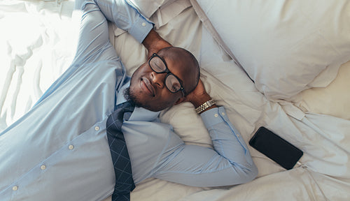 Businessman relaxing on bed