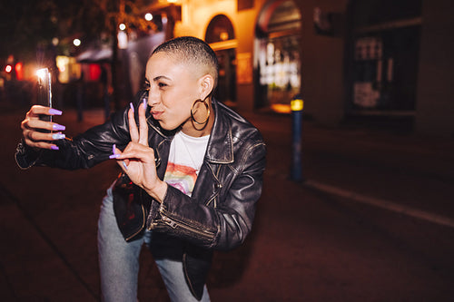 Influencer taking a selfie in the city at night