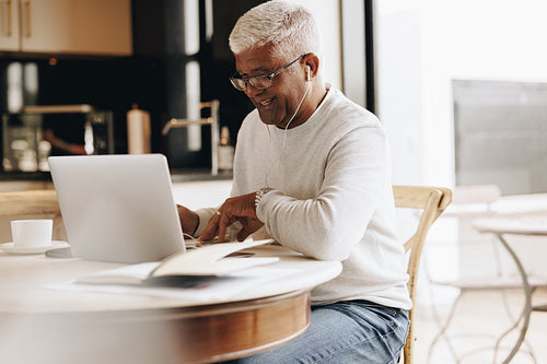 Cheerful senior business man having a virtual meeting at home