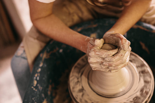 Potter moulding clay on pottery wheel