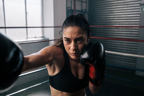 Female boxer training inside a boxing ring