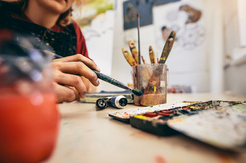 Female artist hand drawing picture with brush