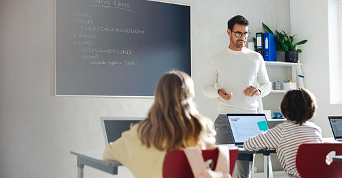 Building young minds: Male teacher teaching kids in a coding class