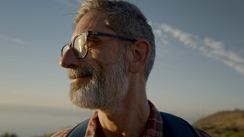 Senior male hiker looking away and smiling