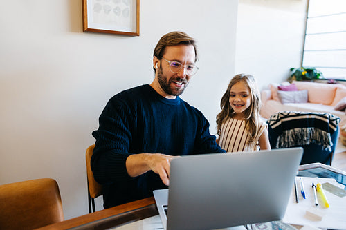 Father and daughter learn on laptop