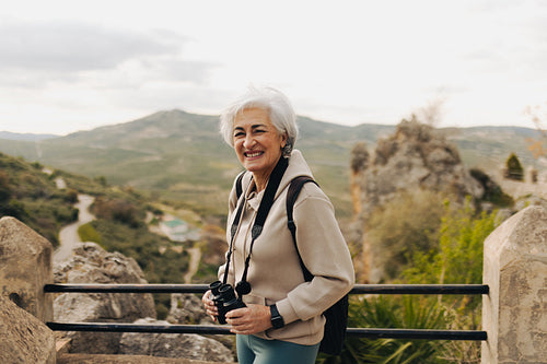Happy elderly woman enjoying a recreational hike outdoors
