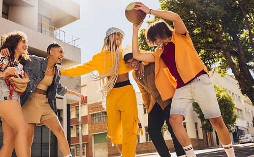Friends playing with a basket ball outdoors
