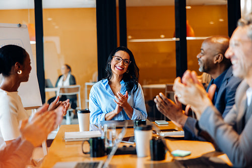 Business team applauding a successful presentation in professional meeting room