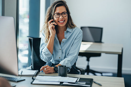 Woman talking on the phone in her business office