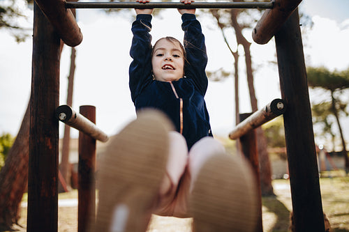 Cute little girl swinging on a metal frame