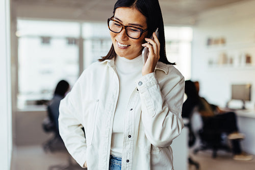 Business woman making a phone call in her workplace