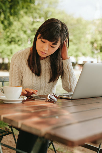 Beautiful young woman using mobile phone at cafe