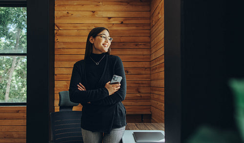 Happy young businesswoman standing in a coworking office
