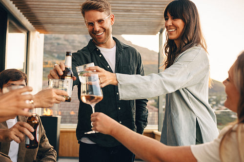 Friends toasting beverages together during a joyful outdoor gathering