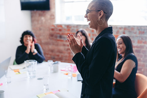 Cheerful businesswoman being applauded by her team