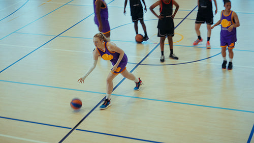 Young woman playing basketball and making shot