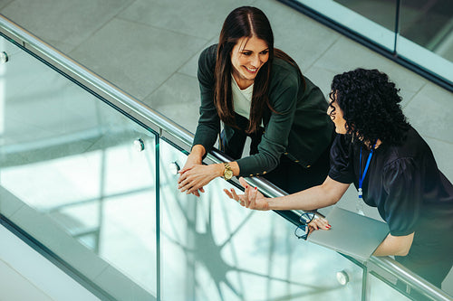Casual conversation between female corporate employees indoors