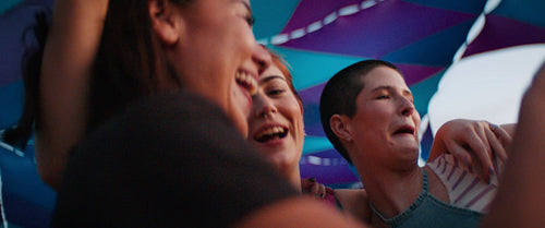 Young female best friends hugging at an outdoor festival