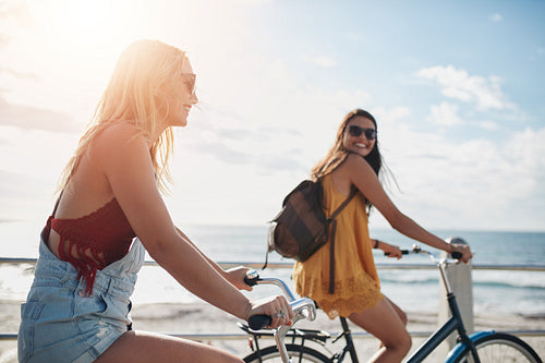 Two women going by bike on sunny day