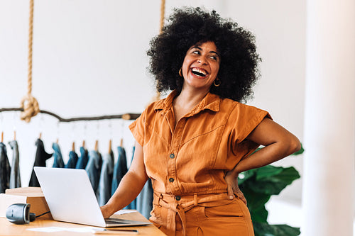 Female small business owner smiling happily in her shop