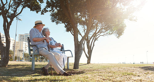 Retired couple relaxing outdoors on a bench