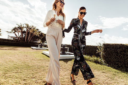 Stylish women walking together and smiling.