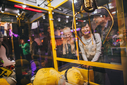 Woman playing toy grabbing game with friends 