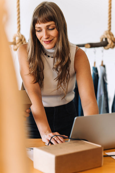 Happy young businesswoman working in an online clothing store