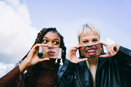 Playful women create face effects with smartphones