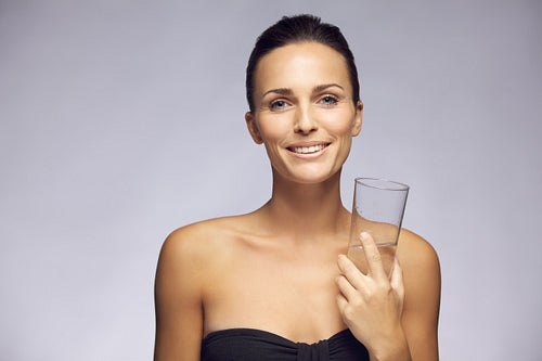 Beautiful young woman with glass of water