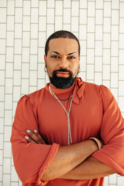 Young drag queen standing with his arms crossed