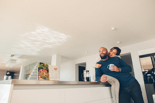 Loving couple enjoying morning coffee in kitchen
