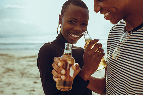 Couple in love drinking beer at beach
