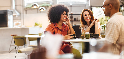 Friends having a good time, chatting over coffee in a restaurant