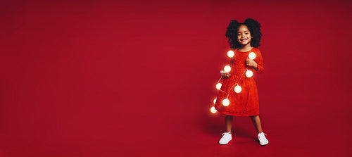 Little girl wearing garland of led bulbs
